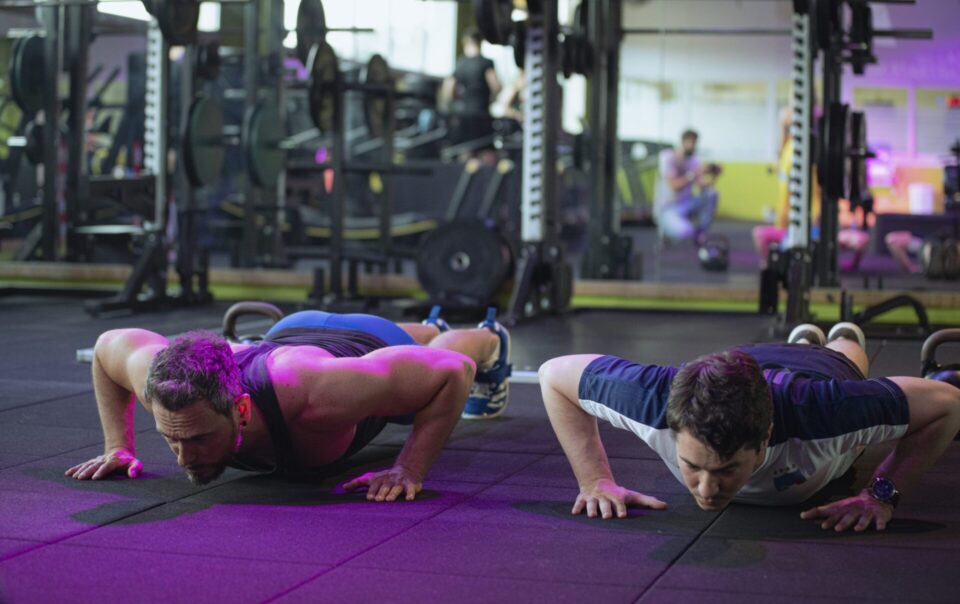 Two men perform push-ups during functional training in the gym at Ego Wellness